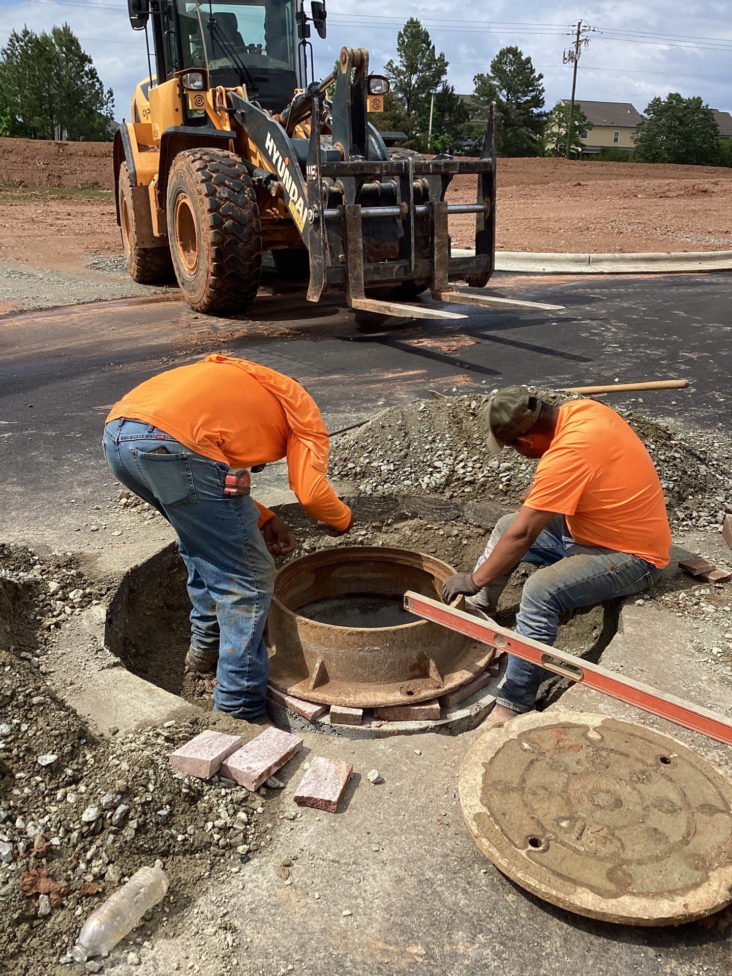 Road repair asphalt patching and manhole adjustment work